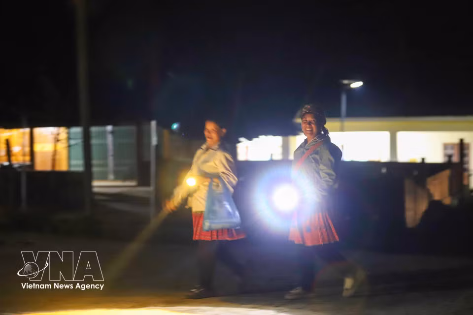 Each carrying a lamp, the women make their way to the classroom in Lang Sang village in search of letters and knowledge. (Photo: VNA)