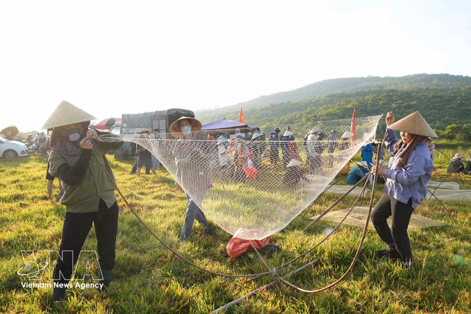 Locals prepare traditional fishing gear before entering the water. (Photo: VNA)