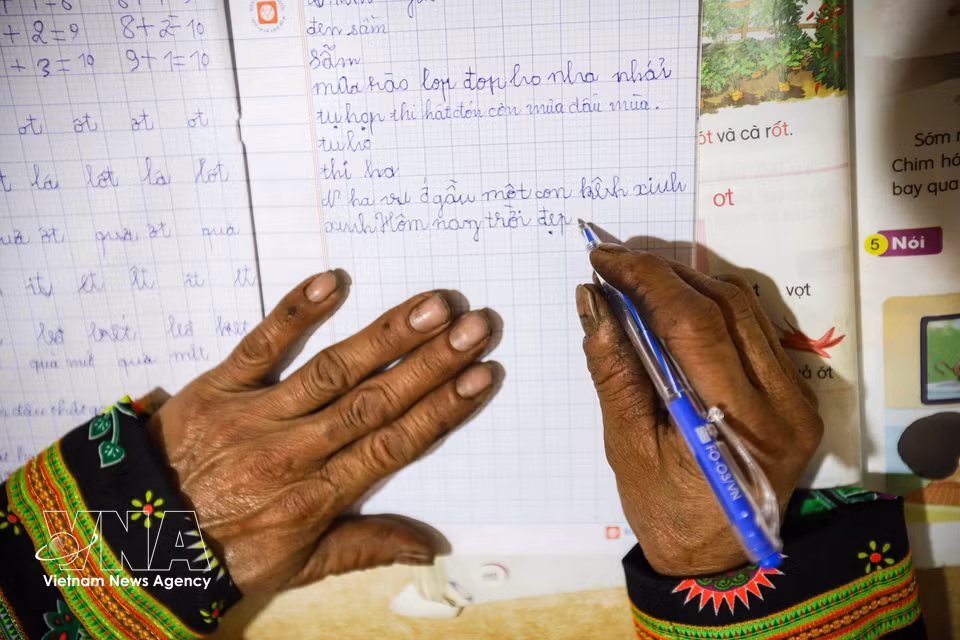 Hands long accustomed to holding hoes and machetes for clearing fields now awkwardly learn to hold a pen. (Photo: VNA)