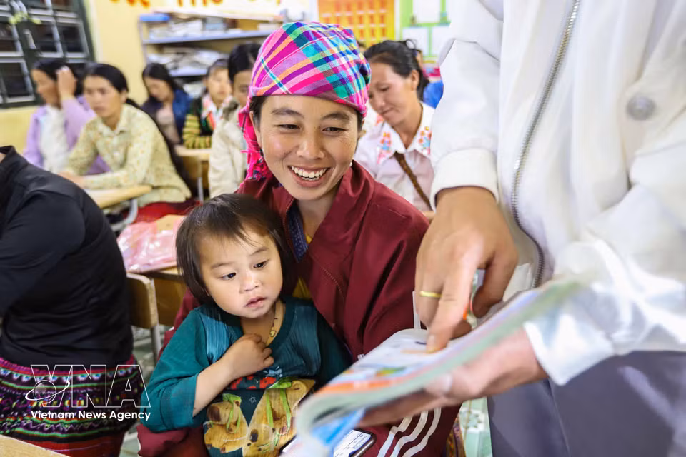 Student Hang Thi Cha reads from a Grade 1 Vietnamese-language textbook under her teacher’s guidance. (Photo: VNA)
