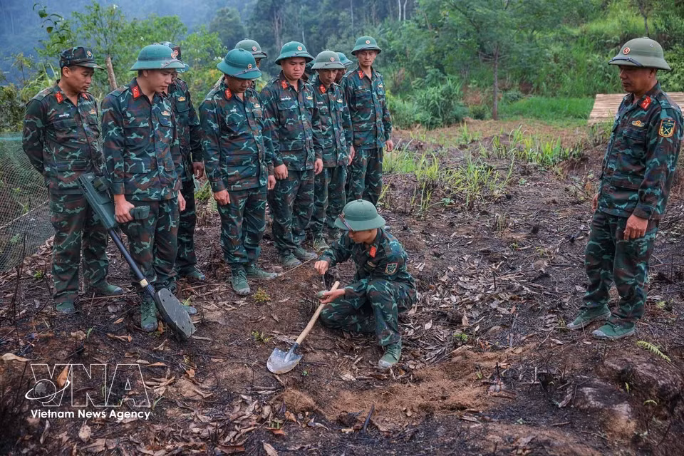 Team members use mine detectors to ensure the search area is “clear” before conducting recovery operations. (Photo: VNA)