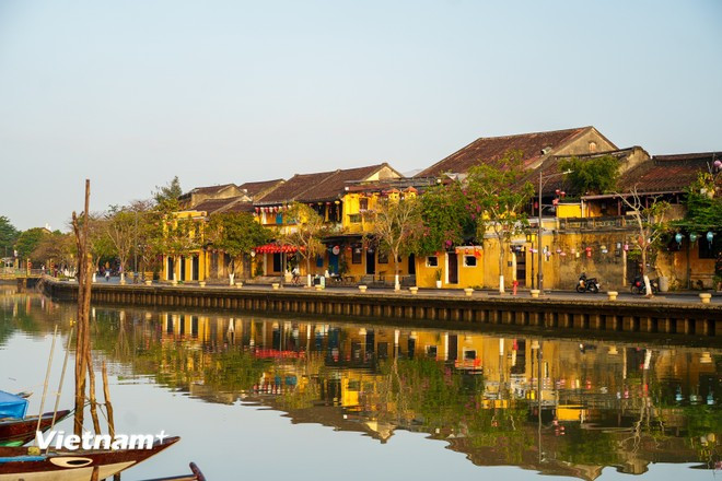 Rows of old houses lie quietly, their reflections mirrored on the Hoai River — a rare moment when the architecture is most fully appreciated. (Photo: VNA)