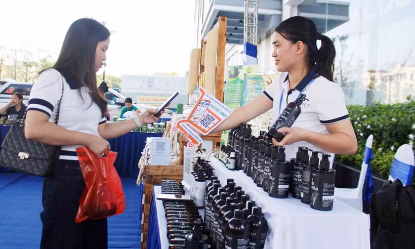A consumer scans a QR code to pay for OCOP products from Viet Ket Herbal Medicine Company Limited in Nhan Thang ward. Photo: Bac Ninh Newspaper.