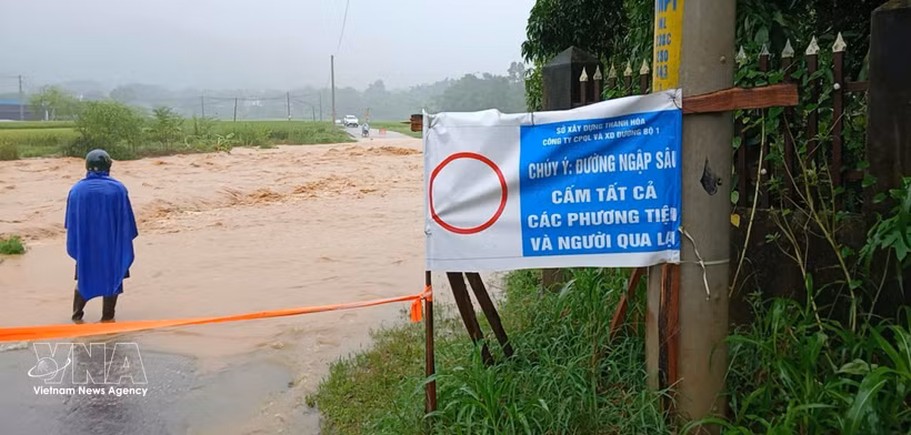 A section of a road in mountainous Thanh Hoa province is submerged under deep floodwaters. Photo published by VNA