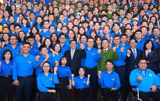 Prime Minister Pham Minh Chinh and officials pose for a group photo with young people at the dialogue on March 24. (Photo: VNA)