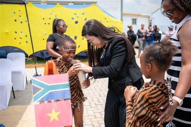 Prime Minister Pham Minh Chinh’s spouse, Le Thi Bich Tran, presents gifts to children in the Tsakane community. (Photo: VNA)