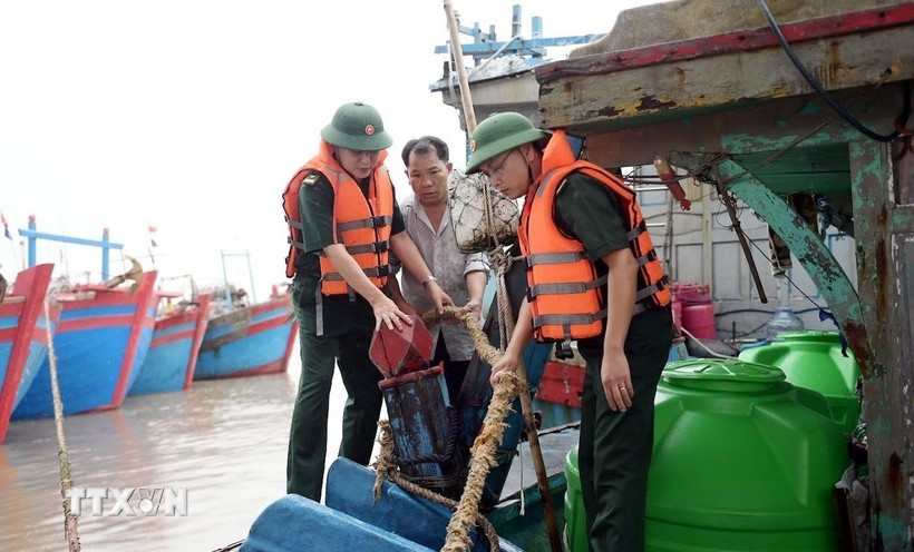 Military officers assist fishermen in Hai Thinh commune, Ninh Binh province, to gear up for the storm. (Photo: VNA)