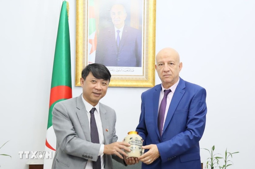 Deputy Editor-in-Chief of the Communist Review Nguyen Ngoc Ha (L) presents a gift to Secretary General of the National Liberation Front (FLN) of Algeria Abdelkrim Benmbarek (Photo: VNA)