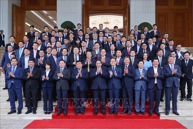 Prime Minister Pham Minh Chinh (centre, first row) poses for a photo with Vietnamese officials and leaders of Korean enterprises. (Photo: VNA)