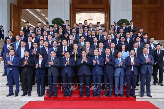 Prime Minister Pham Minh Chinh (centre, first row) poses for a photo with Vietnamese officials and leaders of Korean enterprises. (Photo: VNA)