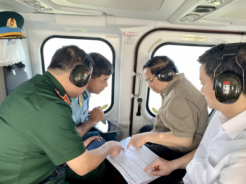 Prime Minister Pham Minh Chinh (second from right) conducts an aerial inspection of the Ca Mau–Dat Mui expressway, the road leading to Hon Khoai, and the dual-use Hon Khoai port from a helicopter. (Photo: VNA) Photo: Duong Giang / VNA 