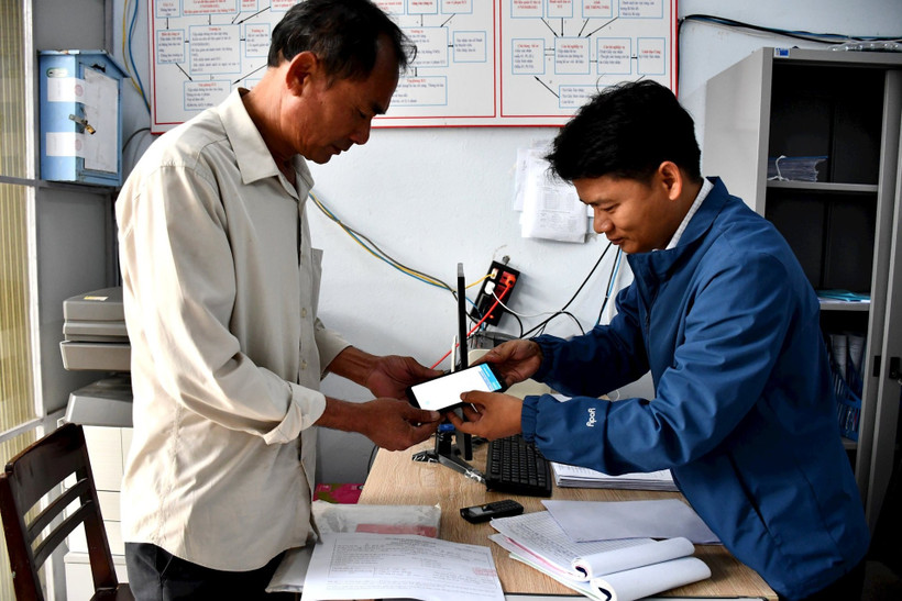 Staff of the Quang Nam Centre for Fishing Vessel Registration and Port Management helps fisherman install, log in to his account, and use the eCDT software. (Photo: baoquangnam.vn)