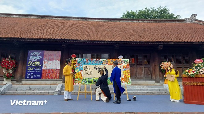 Calligraphers perform calligraphy combined with contemporary art. (Photo: VietnamPlus) man-mieu-3.jpg