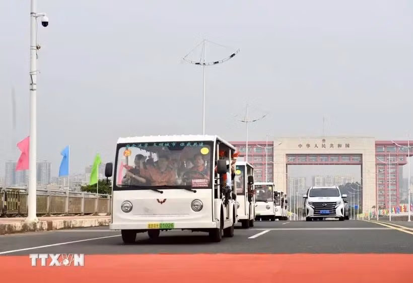 Electric cars carrying tourists passing Bac Luan II bridge (Photo: VNA)