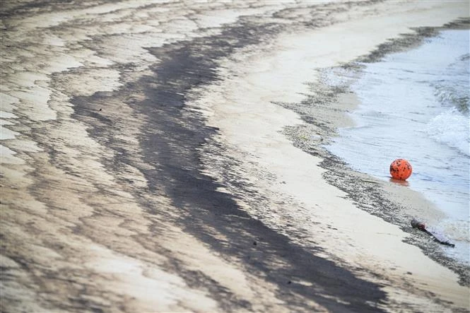 Oil spill on Siloso beach on June 15 (Photo: Xinhua/VNA)