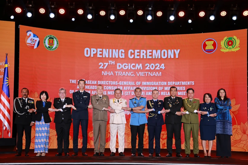 ASEAN directors-general of immigration departments and heads of consular affairs divisions hold hands at the event. (Photo: VNA)