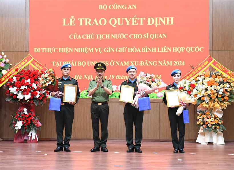 Authorised by the President, Minister of Public Security Sen. Lieut. Gen. Luong Tam Quang presents the decisions to the three officers (Photo: VNA)