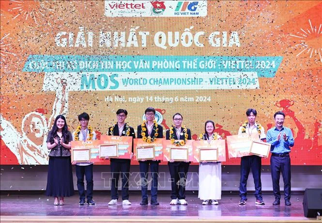 Six champions of the Microsoft Office Specialist (MOS) World Championship - Viettel 2024 receive the tokens of their prizes at the the awards ceremony in Hanoi on June 14. (Photo: VNA)