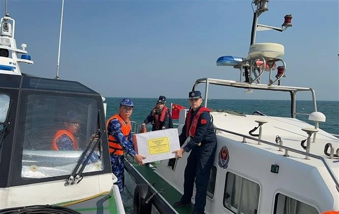 The coast guard forces of Vietnam and China exchange gifts after concluding the joint patrol. (Photo: VNA)