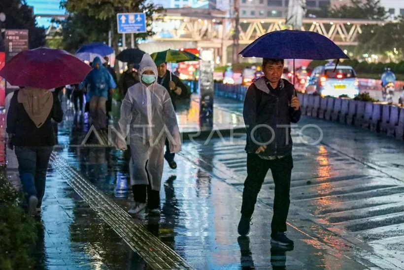 People walk on a rain-drenched street in Jakarta on November 11. (Photo: Antara)