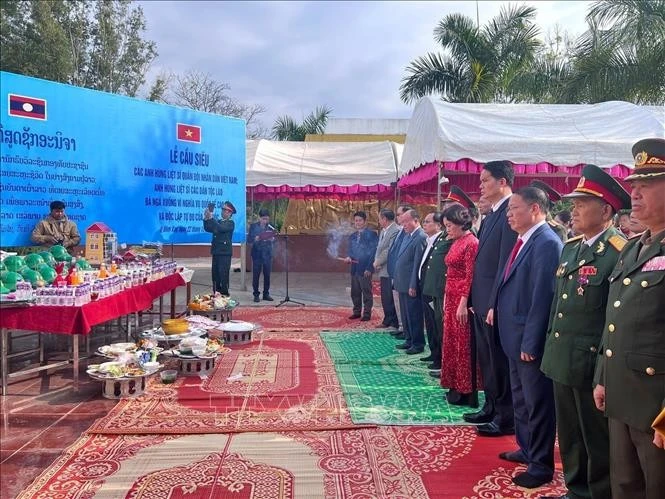 Delegates from Vietnam and Laos observe a minute of silence to commemorate the heroic martyrs of the two nations. (Photo: VNA)