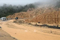 Soil and rocks from the uphill slope spill onto the road surface on Khanh Le pass. (Photo: VNA)