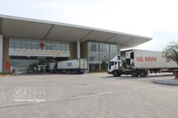 Trucks carrying import and export goods pass through the Lao Cai border gate. (Photo: VNA)