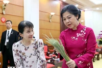 The spouse of Party General Secretary To Lam, Ngo Phuong Ly (R), introduces the spouse of visiting Japanese Prime Minister Ishiba Shigeru, Ishiba Yoshikoand, to the art of making Hanoi’s famed 'banh com'. (Photo: VNA)