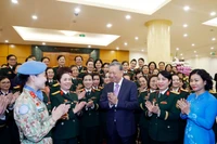 Party General Secretary To Lam (C) meets with outstanding delegates to the eighth congress of military women for the 2025–2030 tenure. (Photo: VNA)
