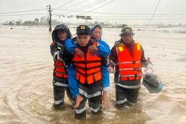 Police officers assist elderly residents in evacuating from deeply flooded areas in Dak Lak province. (Illustrative photo: VNA)