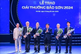 Deputy Prime Minister Nguyen Chi Dung presents flowers to congratulate the winners. (Photo: VNA)