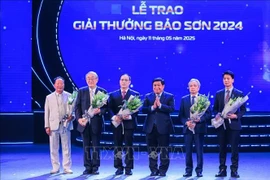 Deputy Prime Minister Nguyen Chi Dung presents flowers to congratulate the winners. (Photo: VNA)