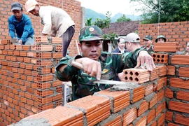 Soldiers of the Quang Ngai provincial Military Command build houses for residents in Tay Tra commune. (Photo: VNA)