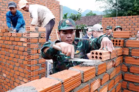 Soldiers of the Quang Ngai provincial Military Command build houses for residents in Tay Tra commune. (Photo: VNA)