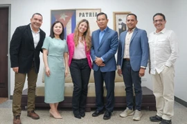 teleSUR President Patricia Villegas (third from left) and Vietnamese Ambassador to Venezuela Vu Trung My (third from right) pose for a photo. (Photo: VNA)