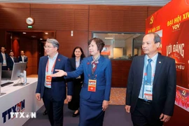 Member of the Party Central Committee and Minister of Justice Nguyen Hai Ninh (L) visits the working area of the Vietnam News Agency at the press centre of the 14th National Party Congress. (Photo: VNA)