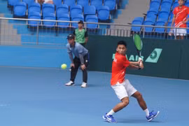 Vu Ha Minh Duc returns a ball to Maximus Jones of Thailand during their singles match at the Davis Cup Asia/Oceania Group III 2025 Pool A on July 14 in Bac Ninh province. (Photo: VTF)