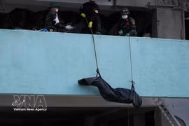 Rescuers retrieve the body of an earthquake victim from the rubble. (Photo: VNA)