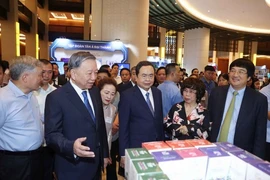Party General Secretary To Lam (second from left), National Assembly Chairman Tran Thanh Man (third from right) and delegates visit an exhibition on achievements in law making and enforcement, and achievements in the development of the private sector. (Photo: VNA)