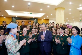 Party General Secretary To Lam (C) meets with outstanding delegates to the eighth congress of military women for the 2025–2030 tenure. (Photo: VNA)