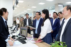 Prime Minister Pham Minh Chinh (in blue shirt) visits the Quang Ninh Public Administration Service Centre (Photo: VNA)