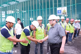 Prime Minister Pham Minh Chinh (R) encourages workers and engineers at the Vietnam Exhibition Fair Centre project site. (Photo: VNA)