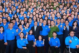 Prime Minister Pham Minh Chinh and officials pose for a group photo with young people at the dialogue on March 24. (Photo: VNA)