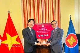 Vietnam’s Ambassador to Austria Vu Le Thai Hoang (R) presents Vietnamese coffee to an international student. (Photo: VNA)