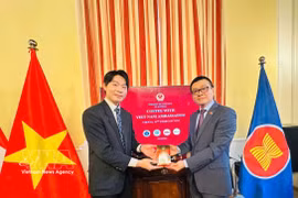 Vietnam’s Ambassador to Austria Vu Le Thai Hoang (R) presents Vietnamese coffee to an international student. (Photo: VNA)