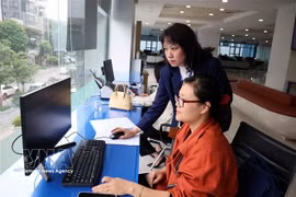 Staff members of the Hanoi Public Administrative Service Centre handle administrative procedures for local residents. (Photo: VNA) 