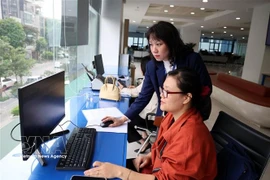 Staff members of the Hanoi Public Administrative Service Centre handle administrative procedures for local residents. (Photo: VNA) 