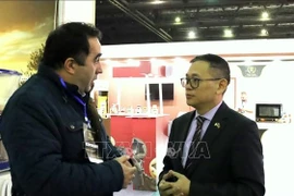 Vietnamese Ambassador to Algeria Tran Quoc Khanh talks with an Algerian businessman at the 7th International Chocolate and Coffee Show in Algeria, on February 4. (Photo: VNA)