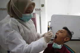A healthcare worker performs a swab test on a patient during influenza symptom screening at a community health centre in Banten, on January 7, 2026. (Photo: antaranews.com)