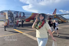 A passenger poses for a photo besides a Vietjet aircraft (Photo: VNA)